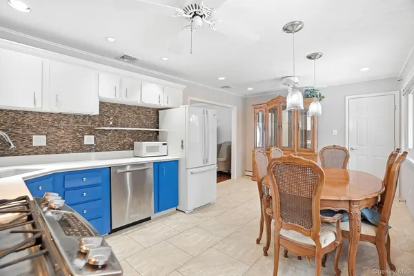 a kitchen with stainless steel appliances kitchen island granite countertop a table chairs sink and cabinets