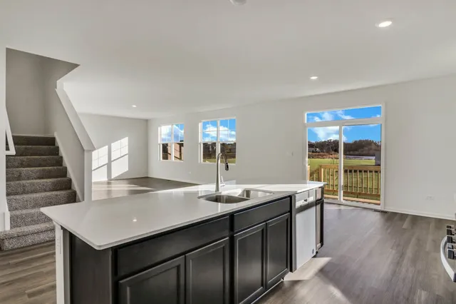 a kitchen with a sink and wooden floor