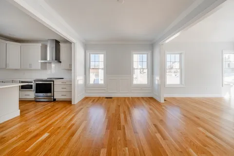 a view of empty room with wooden floor and fireplace