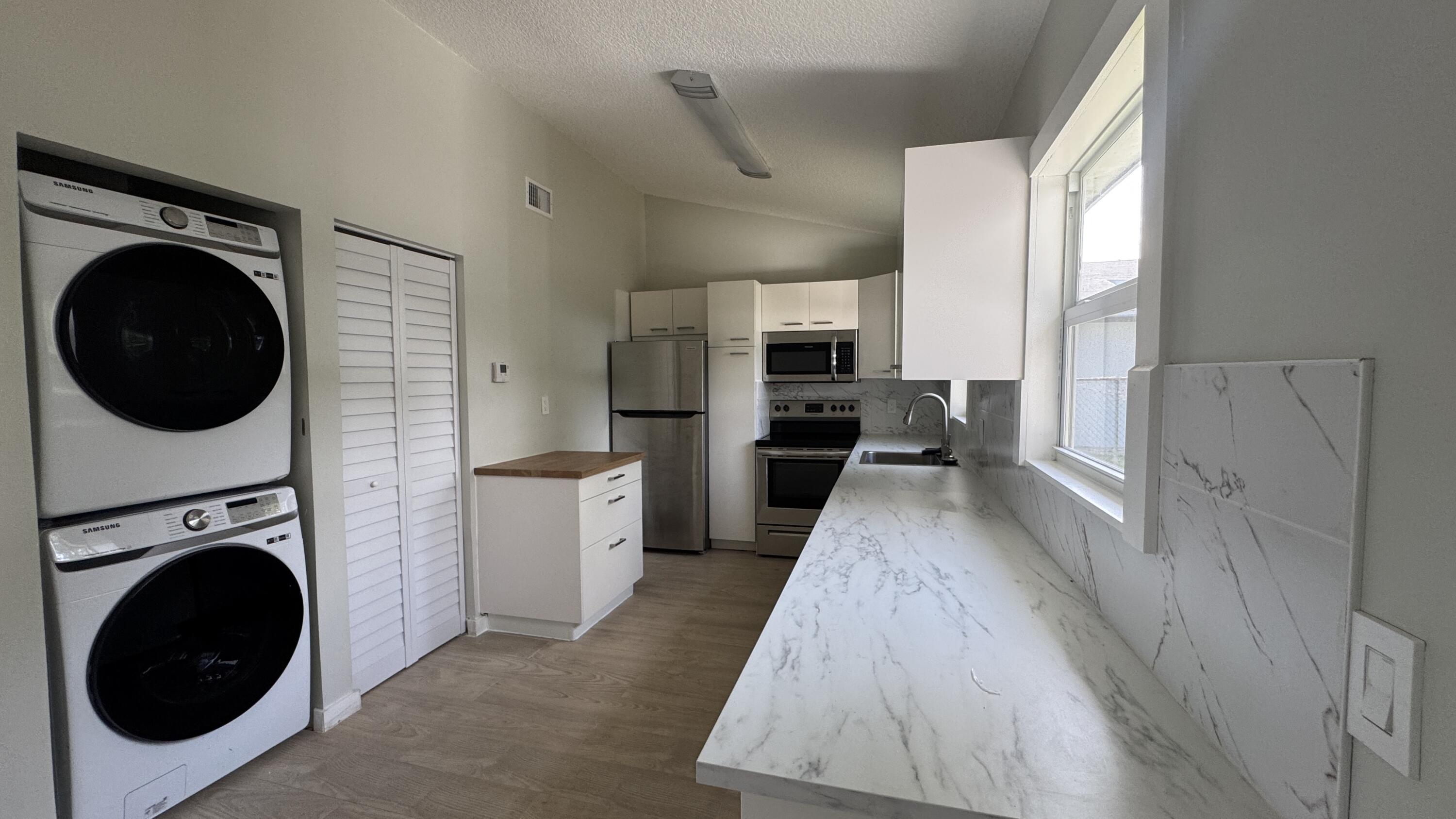 8395 Garden Gate Place Boca Raton, FL 33433 - Photo 6 of 35 a view of a kitchen with a washer and dryer