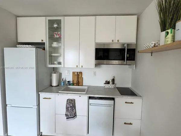 a kitchen with stainless steel appliances granite countertop a refrigerator sink and white cabinets