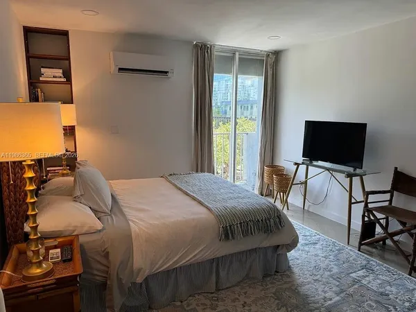 a bedroom with a bed and large windows