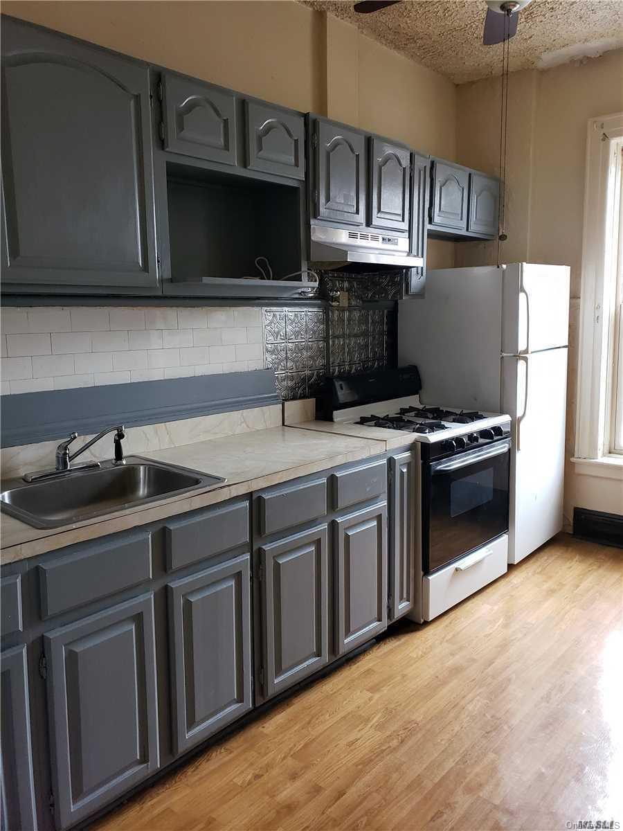 1425 Hancock Street Brooklyn, NY 11237 - Photo 16 of 20 a kitchen with stainless steel appliances a sink a stove a microwave cabinets and a refrigerator