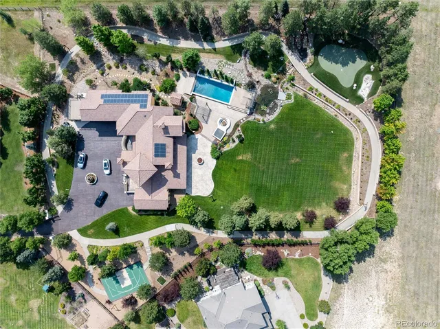 an aerial view of a house with a garden and lake view