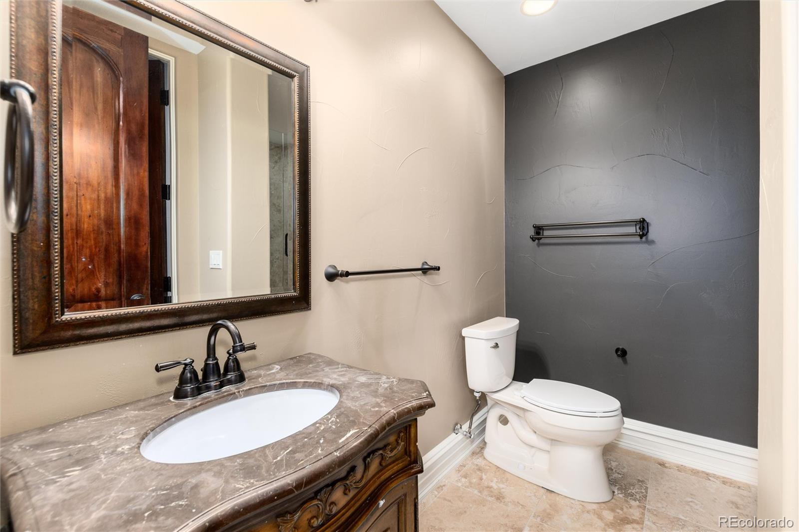 8417 High Ridge Court Castle Pines, CO 80108 - Photo 43 of 48 a bathroom with a granite countertop sink a toilet and mirror