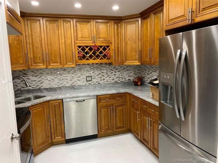 4176 Inverrary Drive, Unit 303 Lauderhill, FL 33319 - Photo 1 of 14 a kitchen with stainless steel appliances granite countertop a refrigerator and a sink