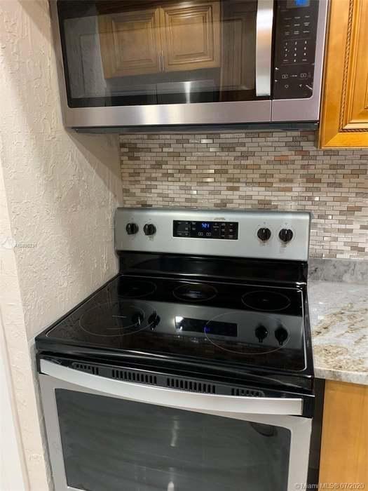 4176 Inverrary Drive, Unit 303 Lauderhill, FL 33319 - Photo 3 of 14 a stove top oven sitting inside of a kitchen