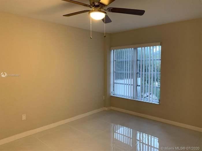 4176 Inverrary Drive, Unit 303 Lauderhill, FL 33319 - Photo 5 of 14 an empty room with a window and ceiling fan