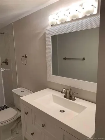 a bathroom with a toilet a sink and shower