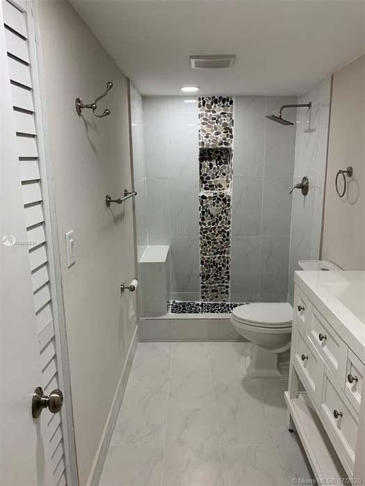4176 Inverrary Drive, Unit 303 Lauderhill, FL 33319 - Photo 9 of 14 a bathroom with a toilet a sink and shower