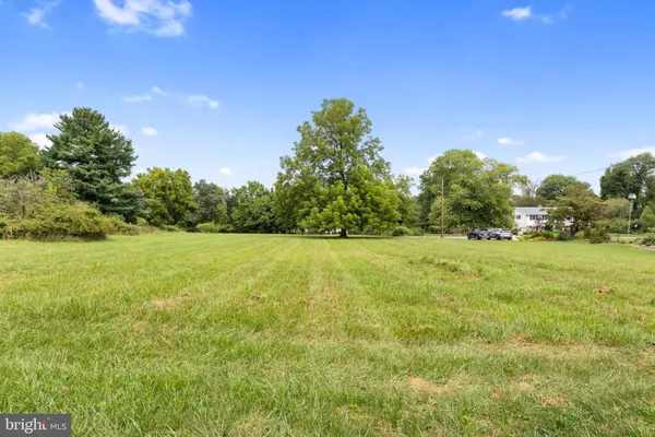 a yard with yellow house in front of it
