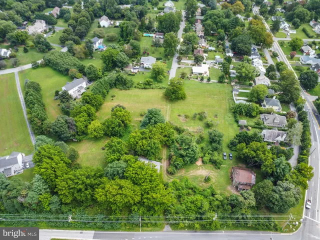 an aerial view of residential houses with outdoor space and trees