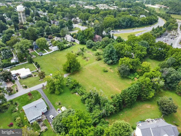 an aerial view of residential houses with outdoor space and lake view