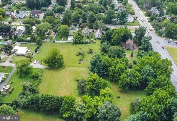 an aerial view of residential houses with outdoor space and trees all around