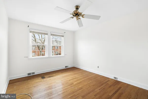 an empty room with a window and a ceiling fan
