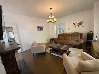 a living room with furniture chandelier and a window