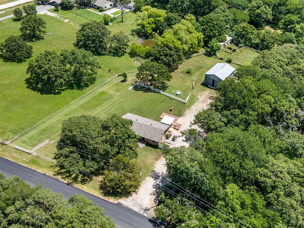 3900 Moseley Road Cross Roads, TX 76227 - Photo 36 of 36 Expansive property featuring a main residence with a pitched roof, a detached barn-style structure with a metal roof, and a large fenced yard area
