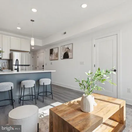 a dining room with furniture a potted plant and a kitchen view