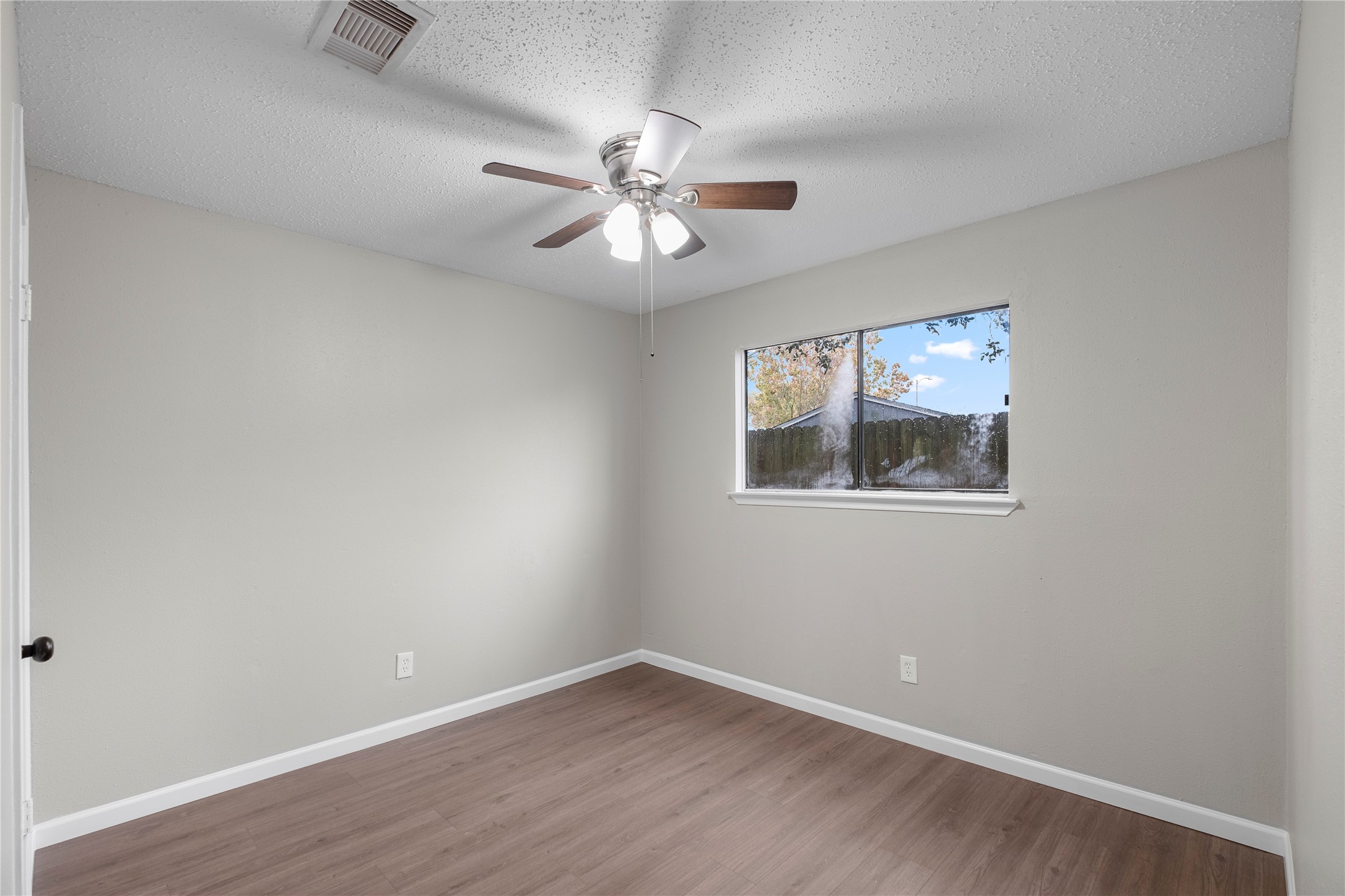 20066 Moonflower Lane Katy, TX 77449 - Photo 19 of 20 an empty room with wooden floor chandelier fan and windows