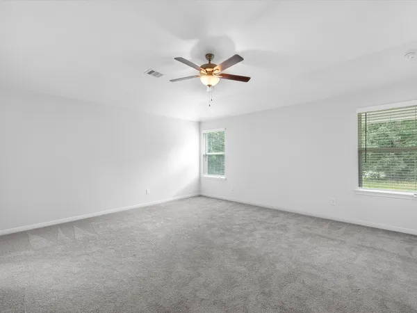 an empty room with a window and a fan