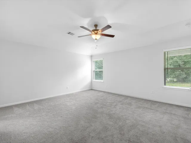 an empty room with a window and a fan