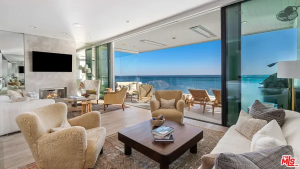a living room with furniture a flat screen tv and a large window