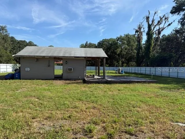 a view of a house with a yard and a large tree