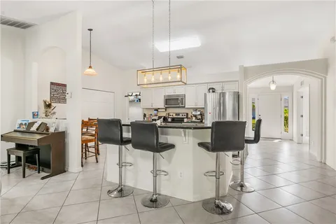 a kitchen with stainless steel appliances kitchen island granite countertop a table and chairs in it