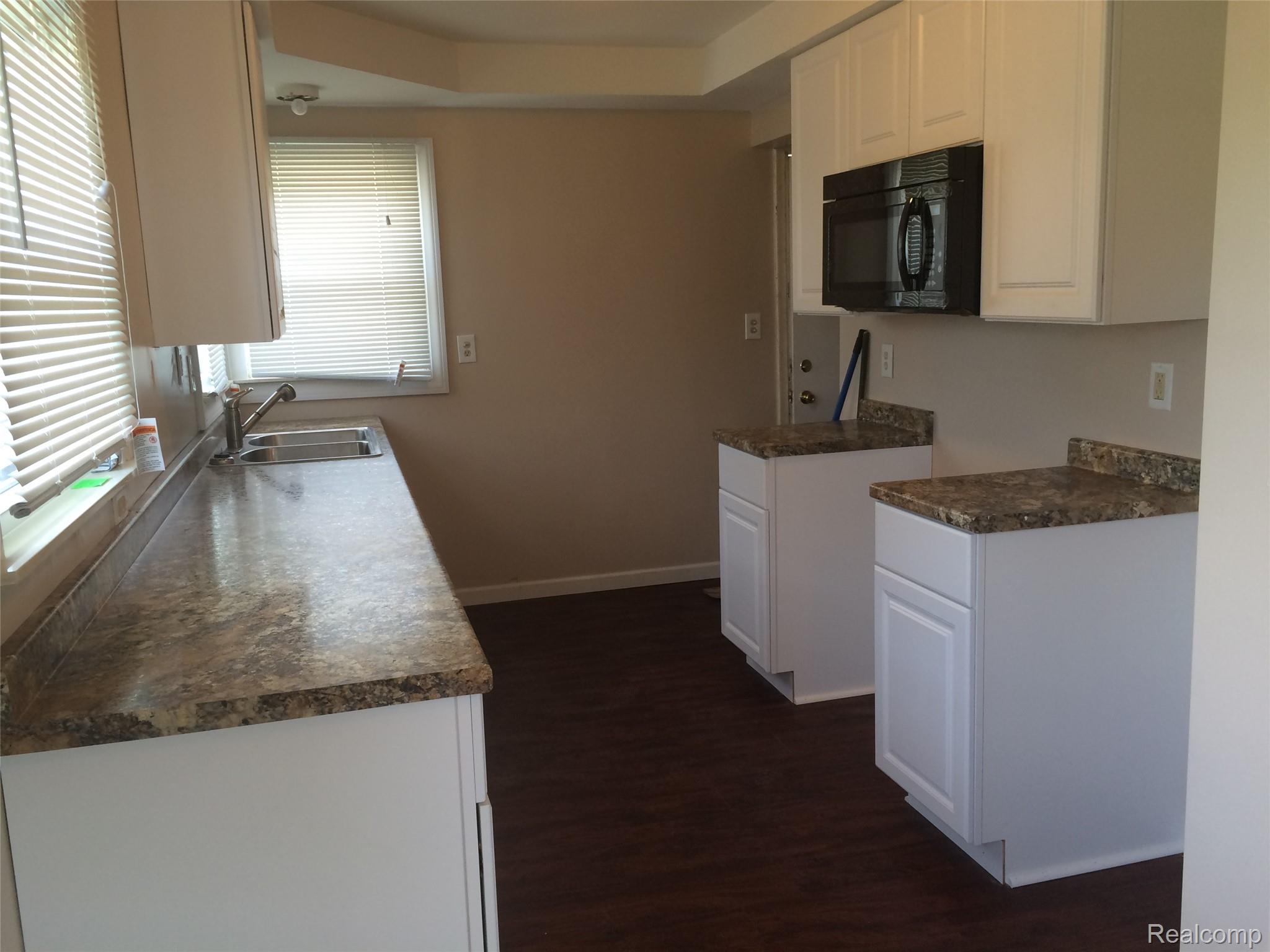 30057 Spring Arbor Drive Inkster, MI 48141 - Photo 1 of 9 Kitchen featuring white cabinetry, brown-toned countertops, stainless steel sink, and dark wood-finish flooring