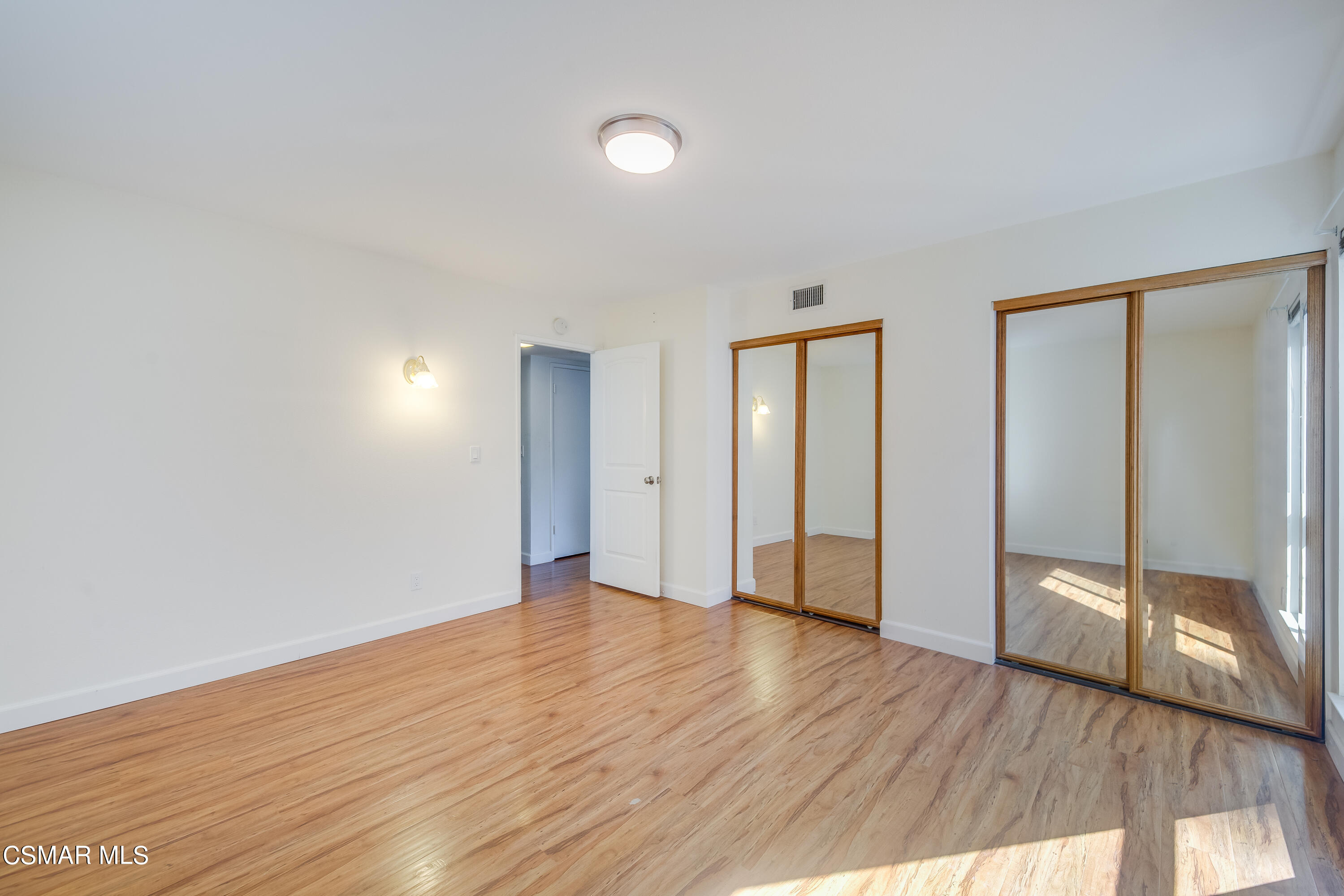 886 Erringer Road Simi Valley, CA 93065 - Photo 12 of 38 a view of an empty room with wooden floor and a window