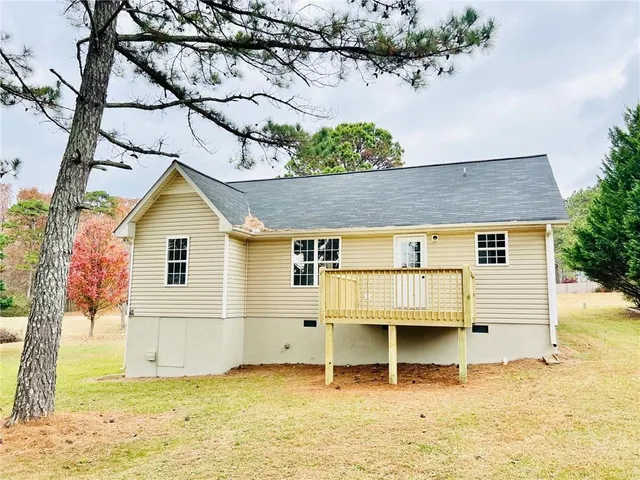 a view of a white house with a yard and potted plants