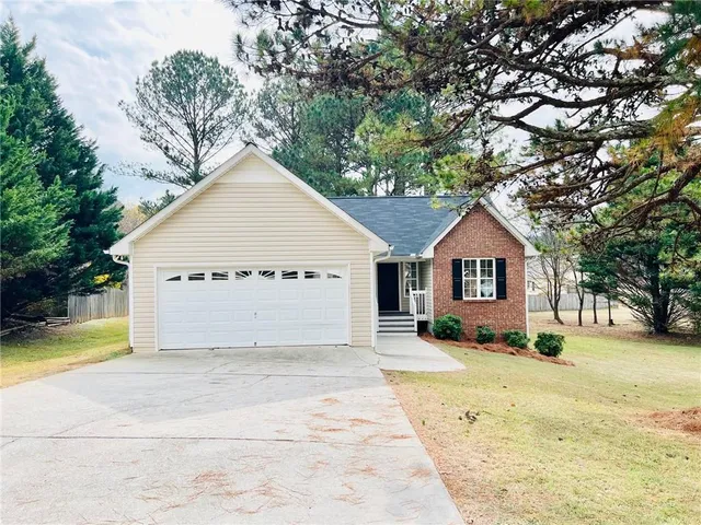 a view of a house with a yard and sitting area