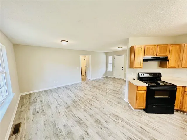a kitchen with granite countertop wooden floors and stainless steel appliances