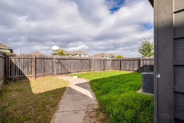 a view of a backyard with swimming pool and sitting area