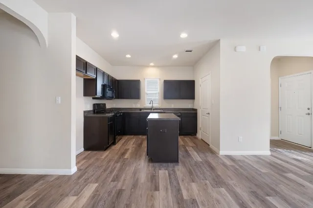 a kitchen with a refrigerator and a stove top oven