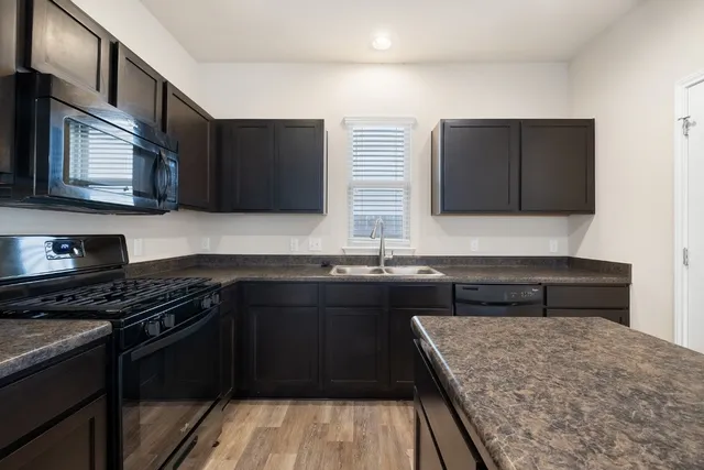 a kitchen with a sink stove top oven and cabinets