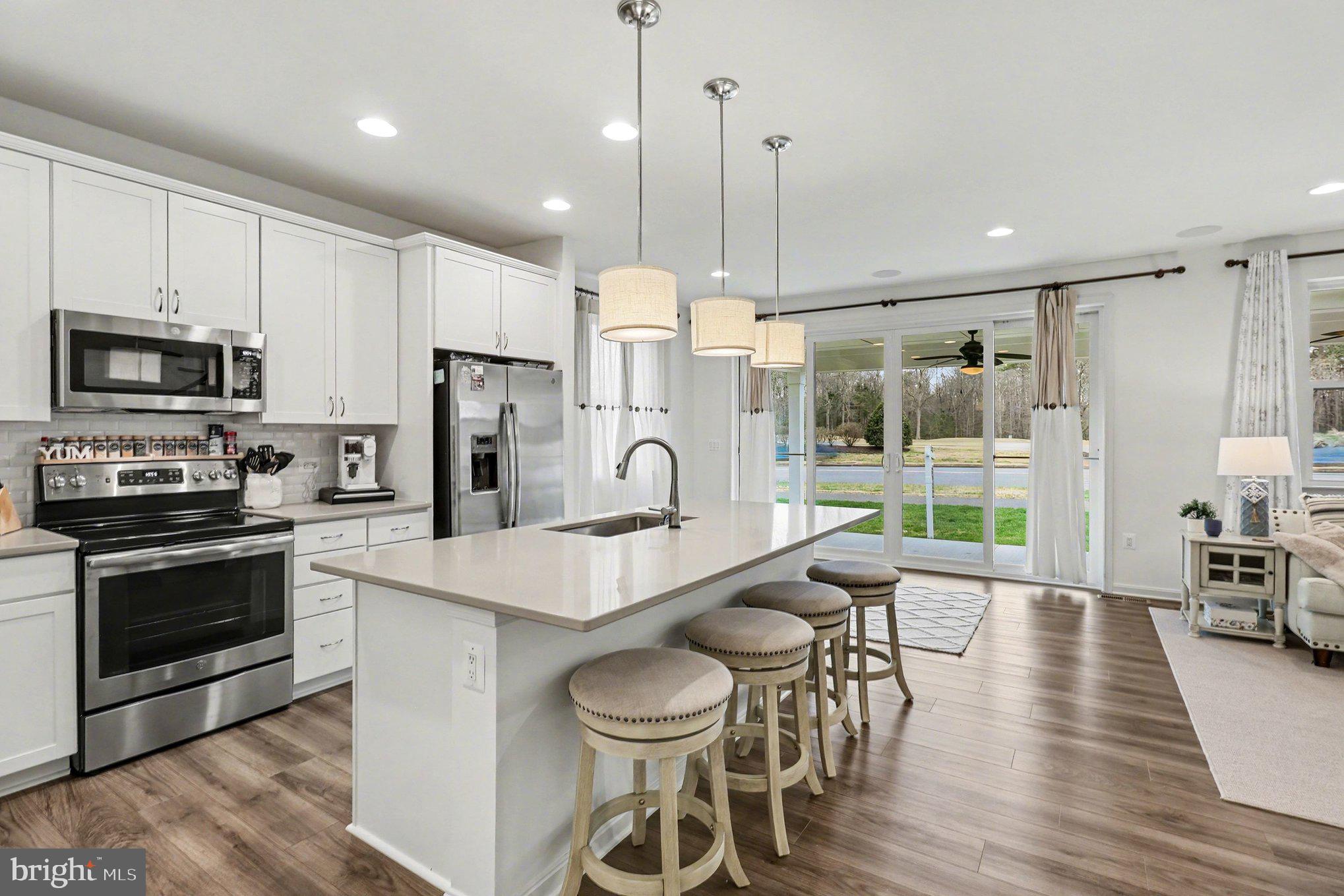 18474 Patriot Lane Ruther Glen, VA 22546 - Photo 8 of 25 a large kitchen with granite countertop a stove a sink a oven a dining table and chairs
