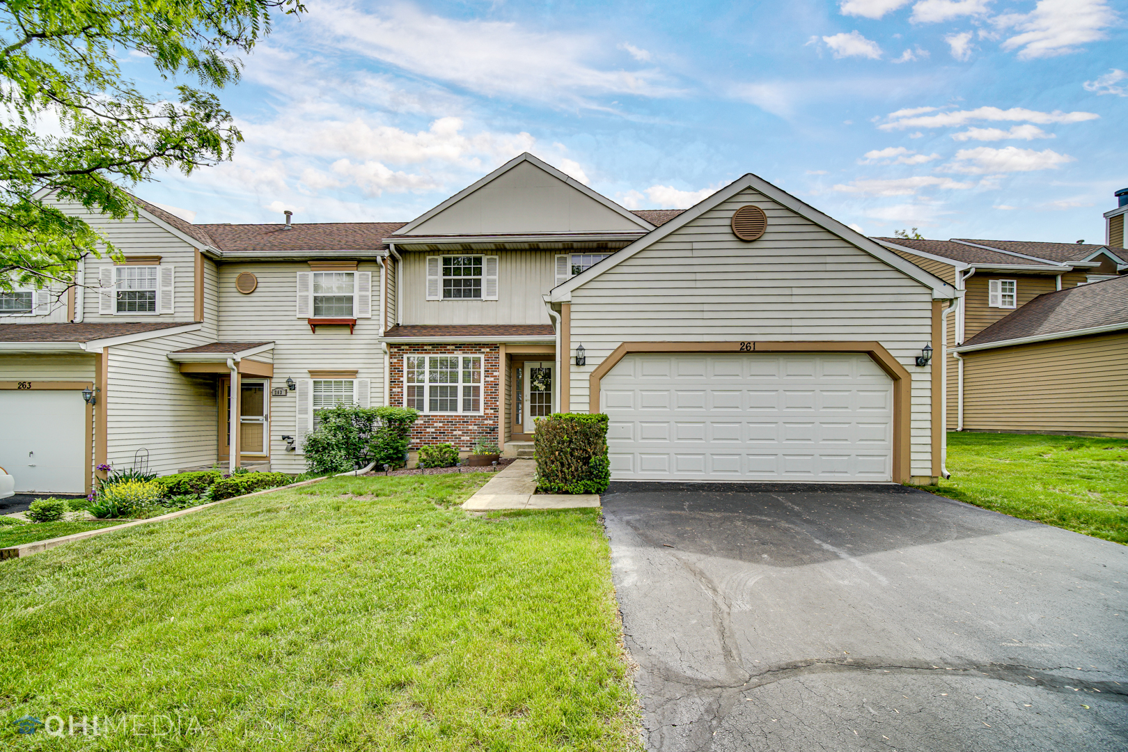261 Ascot Lane Streamwood, IL 60107 - Photo 1 of 23 a front view of a house with a yard and garage