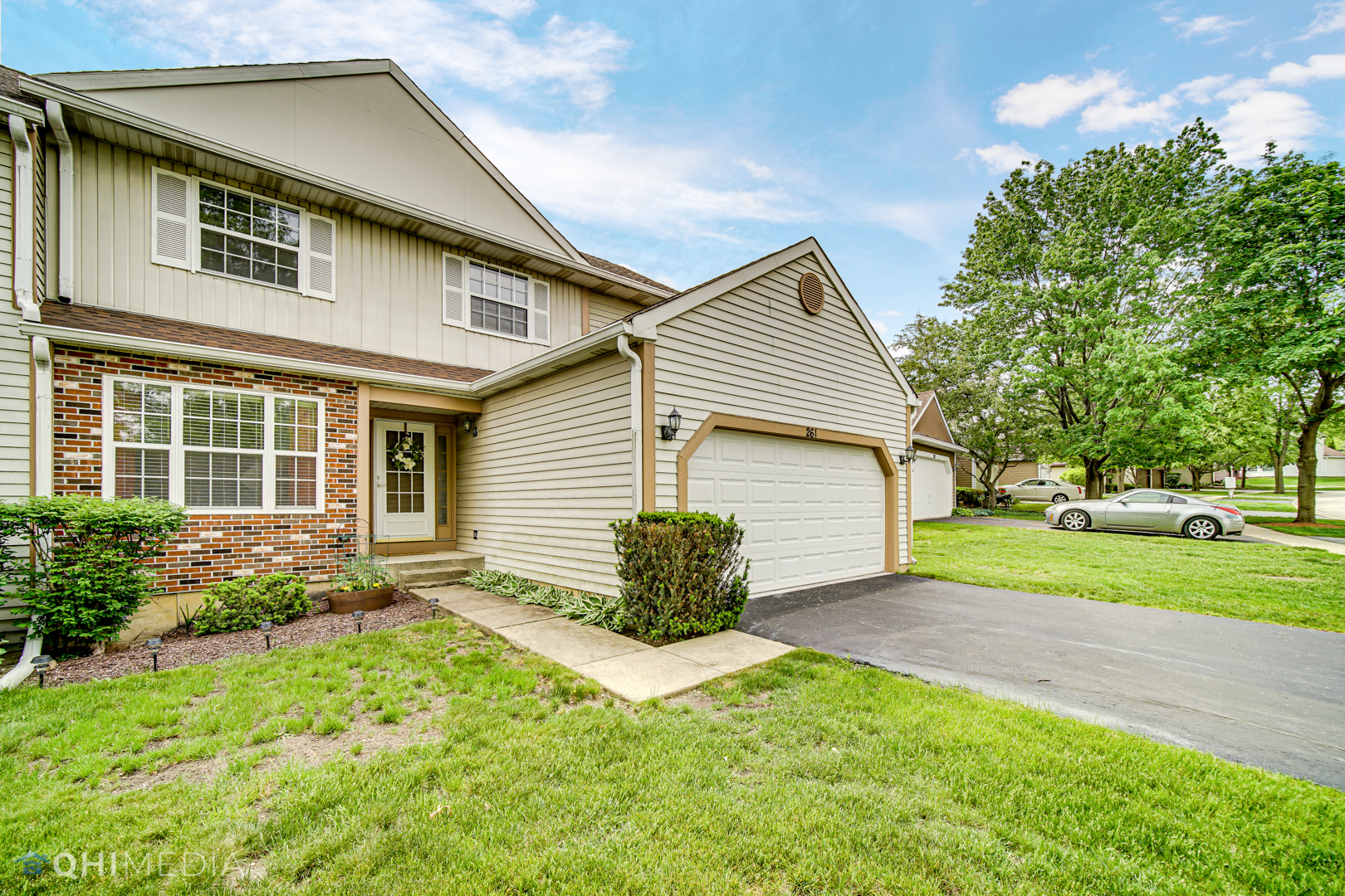 261 Ascot Lane Streamwood, IL 60107 - Photo 2 of 23 a front view of a house with garden