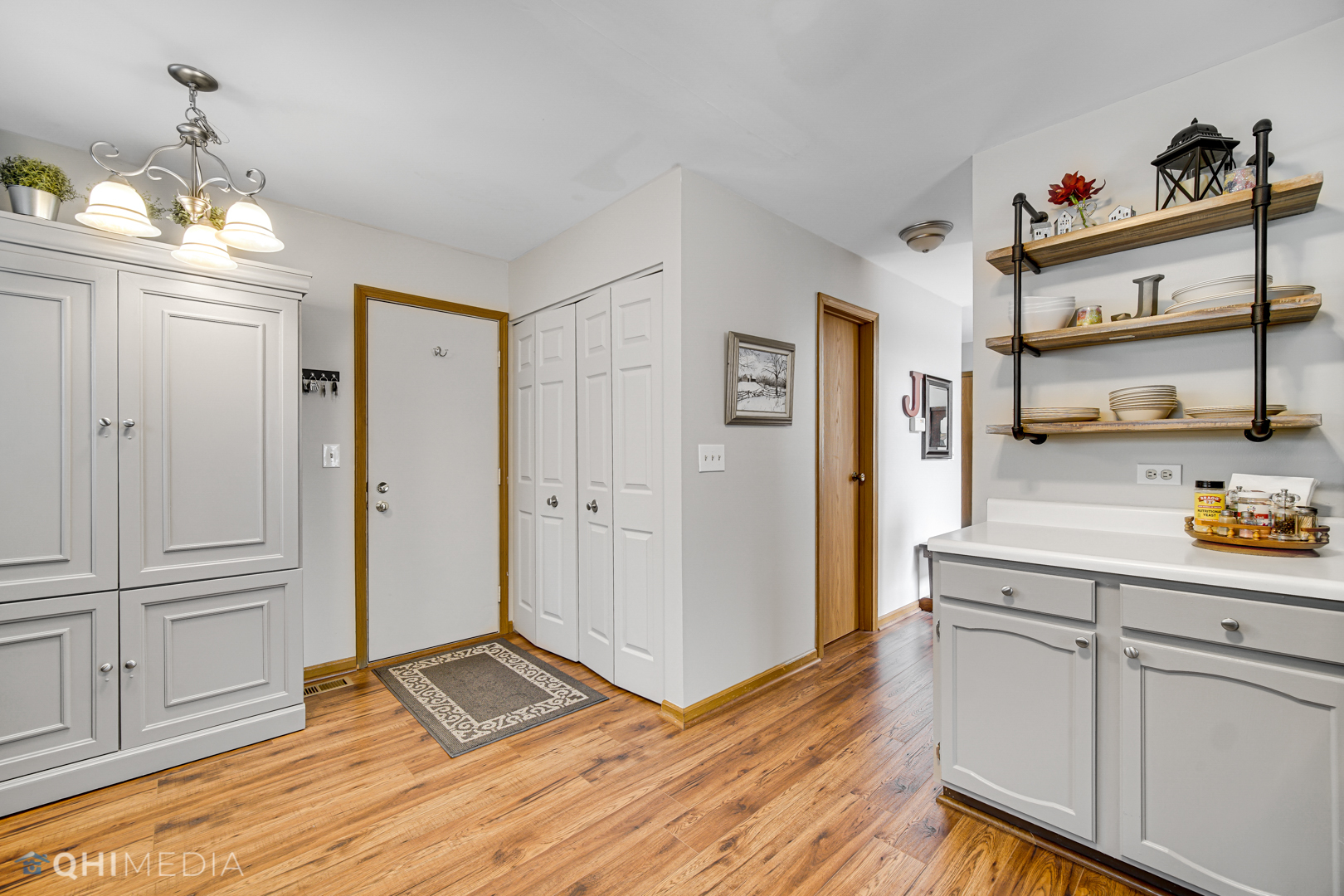 261 Ascot Lane Streamwood, IL 60107 - Photo 8 of 23 a open kitchen with white cabinets and wooden floor