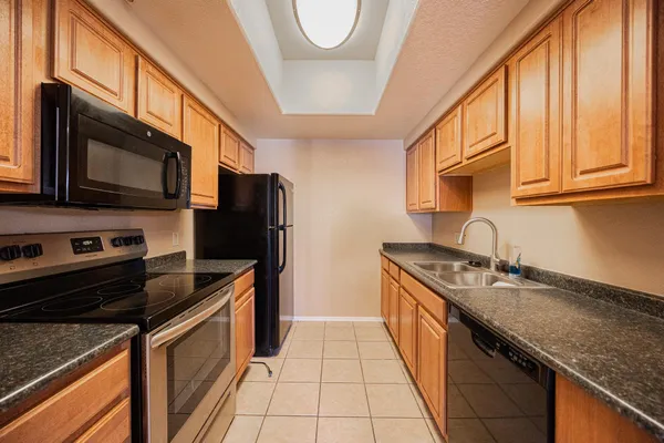 a kitchen with stainless steel appliances granite countertop a sink stove and refrigerator