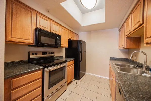 a kitchen with stainless steel appliances a stove a sink a microwave and cabinets