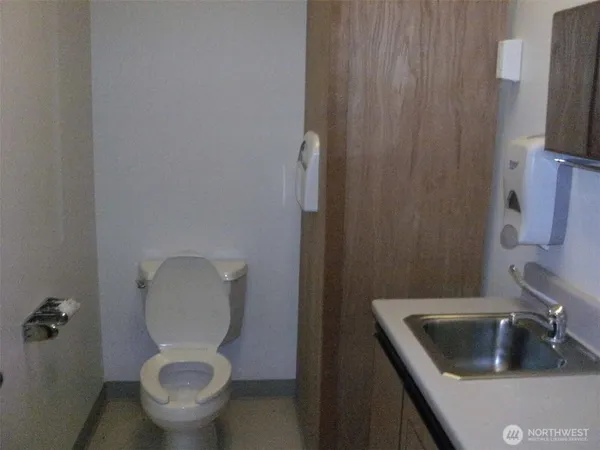a room with water heater and wooden cabinets
