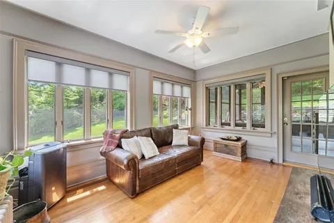 a living room with furniture and a large window with wooden floor