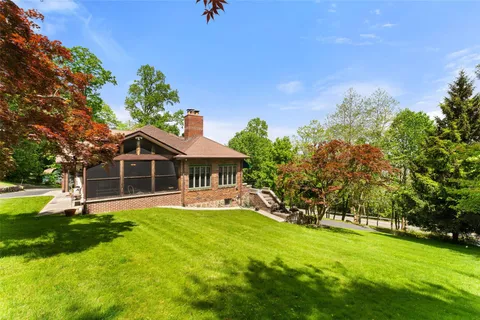 an aerial view of a house with a garden and lake view