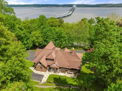 an aerial view of a house with a yard and large trees
