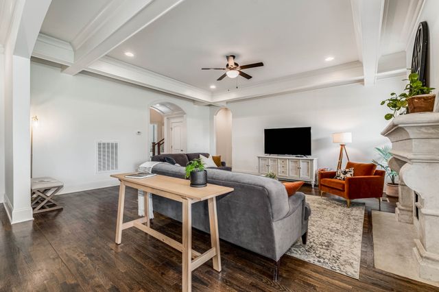 a kitchen with stainless steel appliances granite countertop a dining table chairs refrigerator and microwave