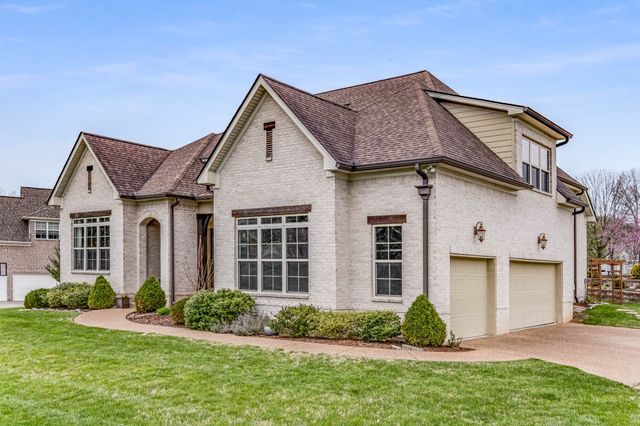 a front view of a house with a yard and plants