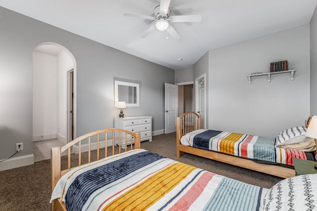 a bed sitting in a spacious bedroom next to a window
