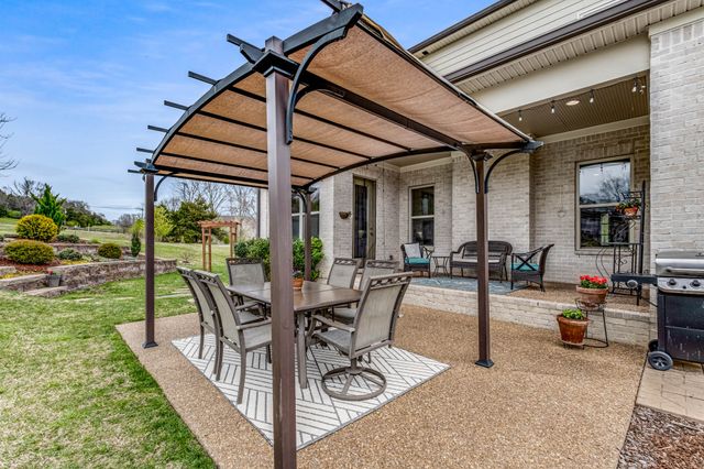 a view of a house with a yard patio and fire pit